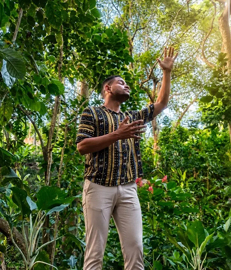 Kellson Sousa, dirigente do Instituto Essência Una, de braços erguidos na floresta